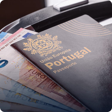 Portuguese passport resting on Euro banknotes, illustrating the financial investment requirements for the Golden Visa program.