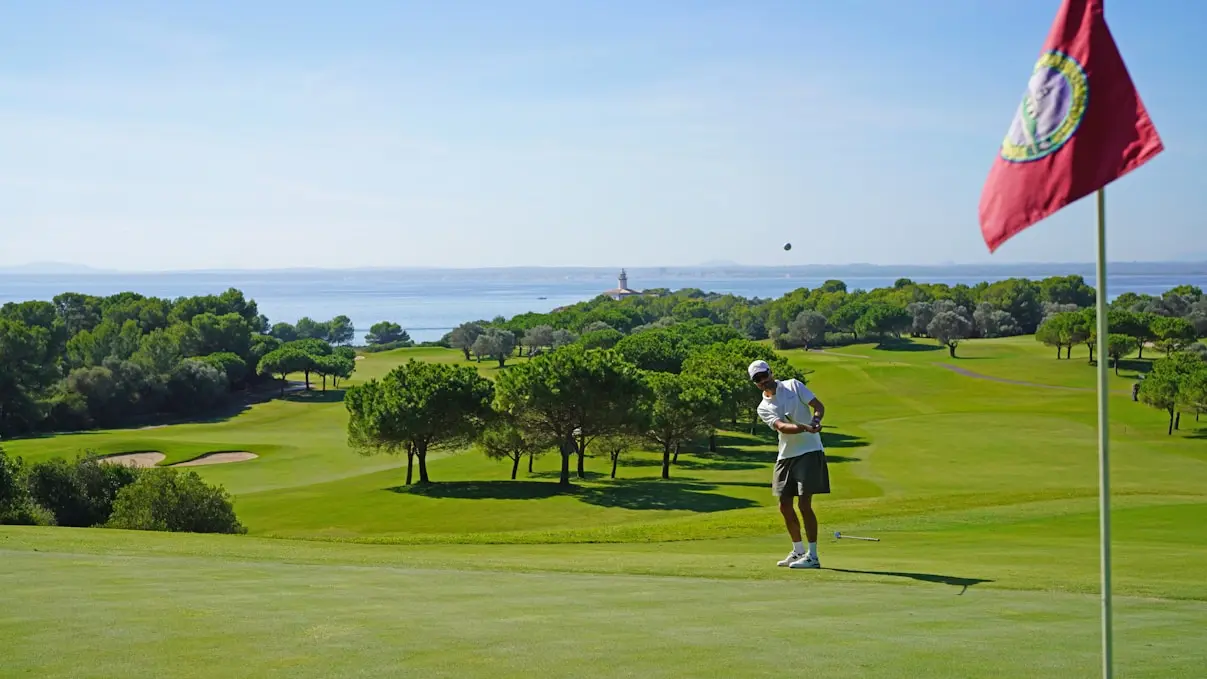 Golfer playing on a sunny luxury golf course in Portugal with ocean views, illustrating the premium lifestyle available to Golden Visa investors.